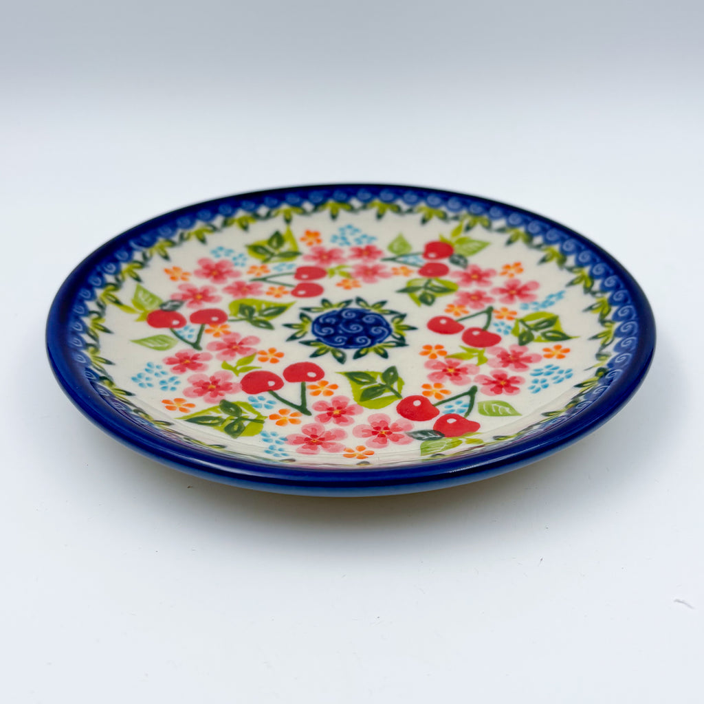 UNIKAT Cherry Blossom plate, front view showing red cherries and pink blossoms on scalloped rim