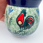 Close-up of rooster design on Rooster Parade bubble mug, held in hand