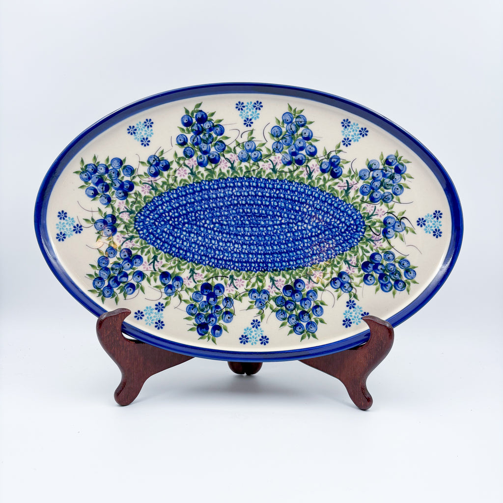 UNIKAT Blueberry oval tray, front view on stand showing blueberry clusters and mosaic center band