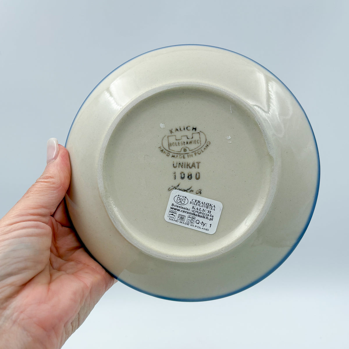 UNIKAT Cherry Blossom plate held in hand, bottom stamp with Kalich Boleslawiec Unikat mark