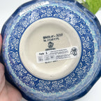 Bottom of Deep Winter scalloped bowl showing Unikat stamp and artist signature, held in hand