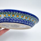 UNIKAT Songbird Garden oval Milano platter, exterior side view held in hand showing bottom stamp and daisy border