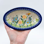 UNIKAT Songbird Garden oval Milano platter held in hand, top-down view showing full oval platter with songbird