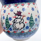 Close-up of snowman design on Snowman Stroll bubble mug, held in hand