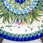 UNIKAT Snowdrop Garden plate, close-up rim detail showing snowdrops, crocuses, and green grass burst