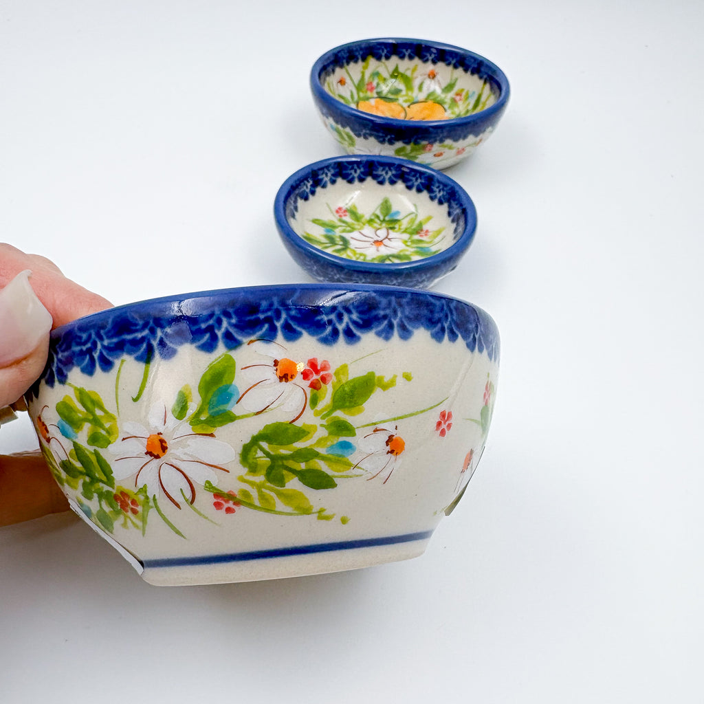 UNIKAT Orange Poppy small stacking bowl set, large bowl held in hand with two smaller nested bowls beside it