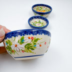 UNIKAT Orange Poppy small stacking bowl set, large bowl held in hand with two smaller nested bowls beside it