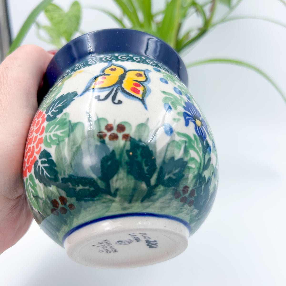 Spring Garden bubble mug held in hand, side view showing butterfly and pink flower
