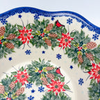 Christmas Cardinals wavy bowl, close-up rim detail showing cardinal, poinsettias, and blue snowflakes