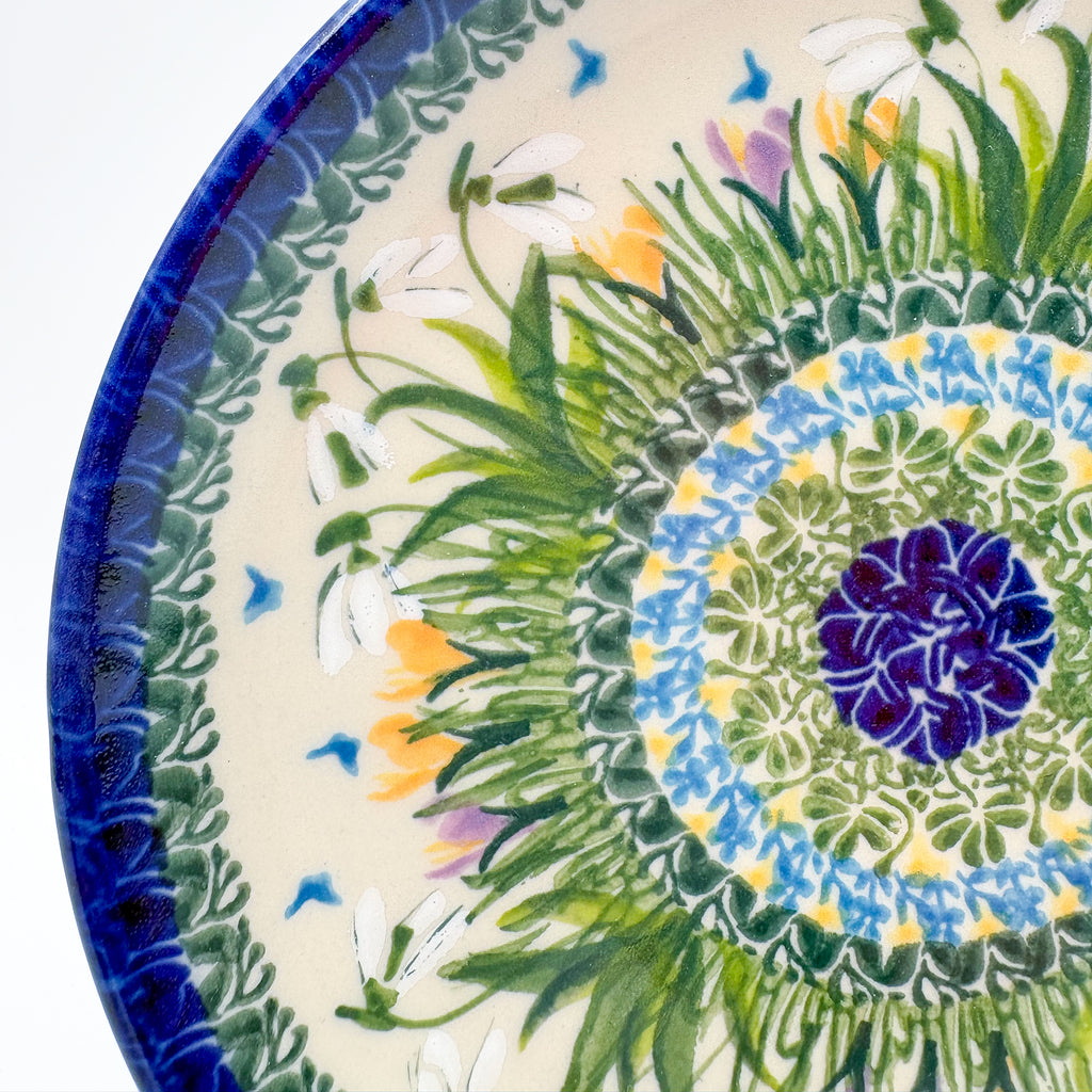 UNIKAT Snowdrop Garden plate, close-up top-down view of blue center ring and green grass burst