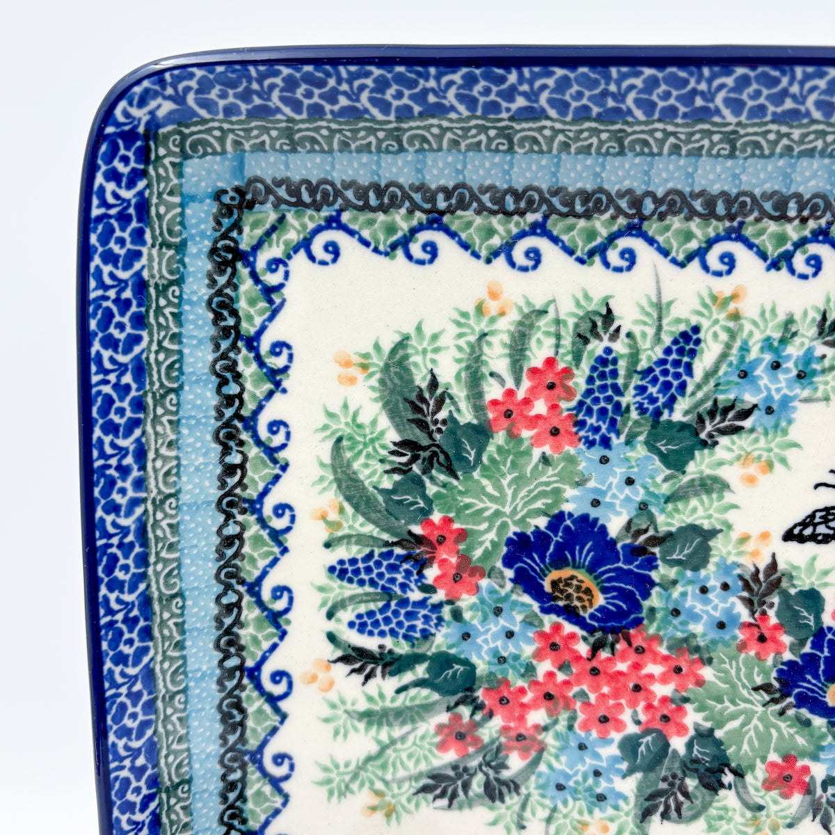 Mariposa rectangular platter, close-up corner view showing scroll border layers and floral bouquet edge