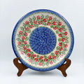 Midsummer Bloom plate, front view displayed on wooden stand showing red flower ring around blue center