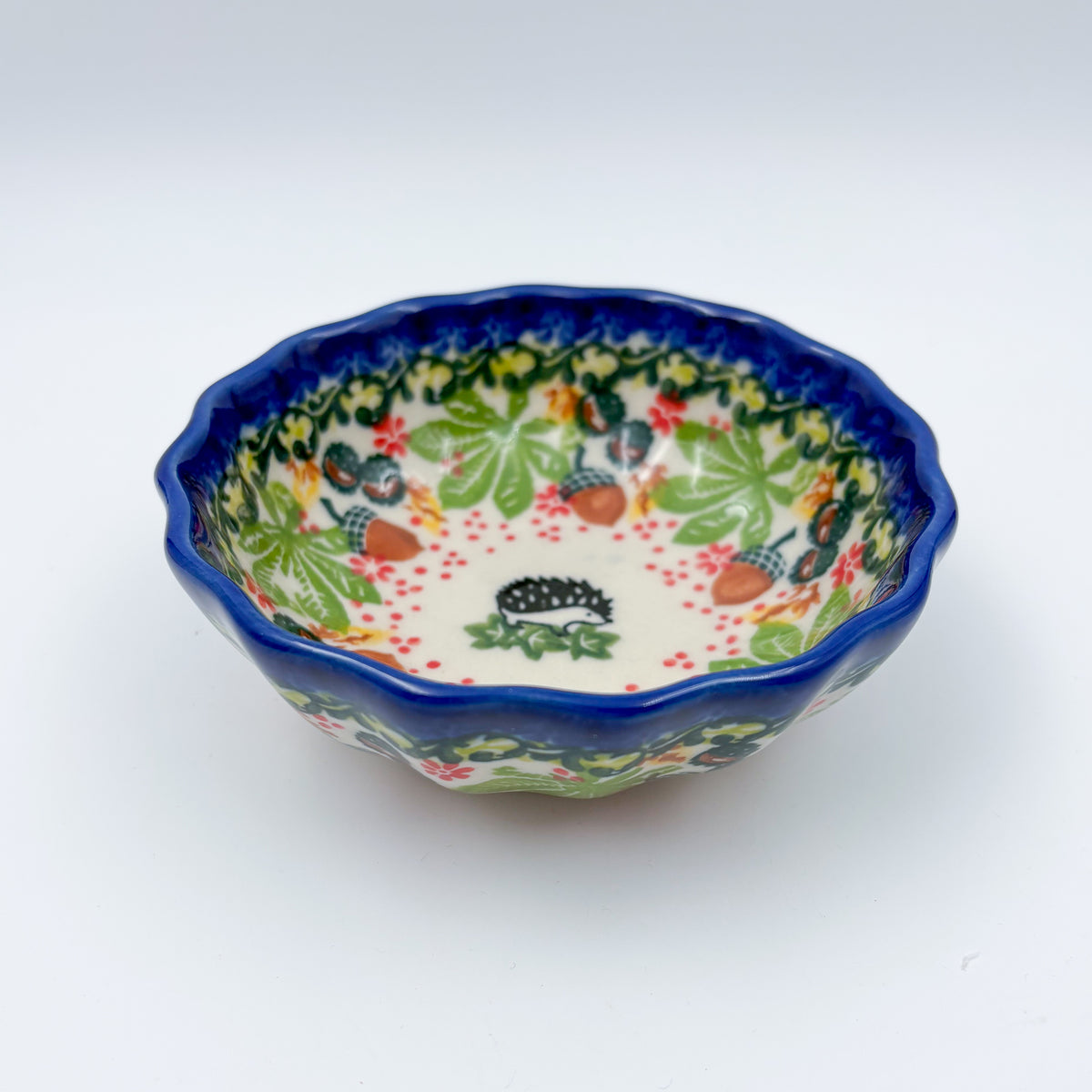 UNIKAT Hedgehog and Pumpkin scalloped bowl, front view showing scalloped rim with acorns and autumn leaves