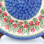 Midsummer Bloom plate, close-up rim view of red flower ring on scalloped blue border