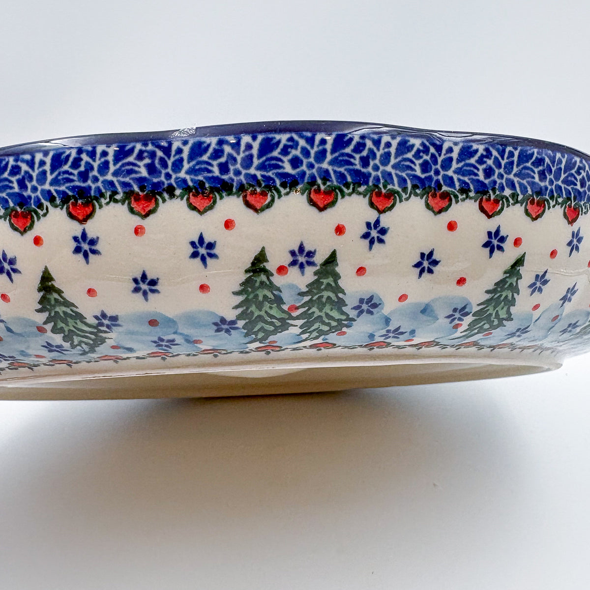 Dancing Snowman chip and dip platter, exterior side view showing pine trees and heart-dot border pattern