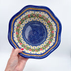 Mushroom Design wavy bowl, top-down view held in hand showing mushroom wreath around blue dotted center