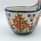 Close-up of red berry cluster pattern on loop-handle bowl mug