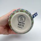Bottom of Fowls in Florals bubble mug showing Ceramika Bona Unikat stamp, held in hand