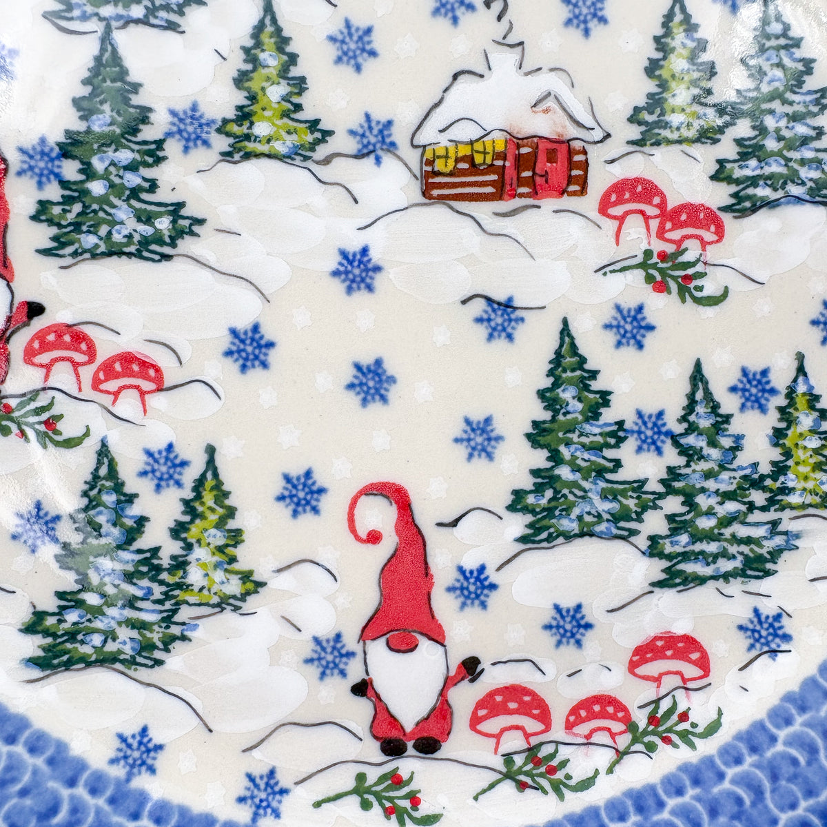 UNIKAT Gnome Village plate, close-up top-down view of two gnomes among pine trees and cabin scene