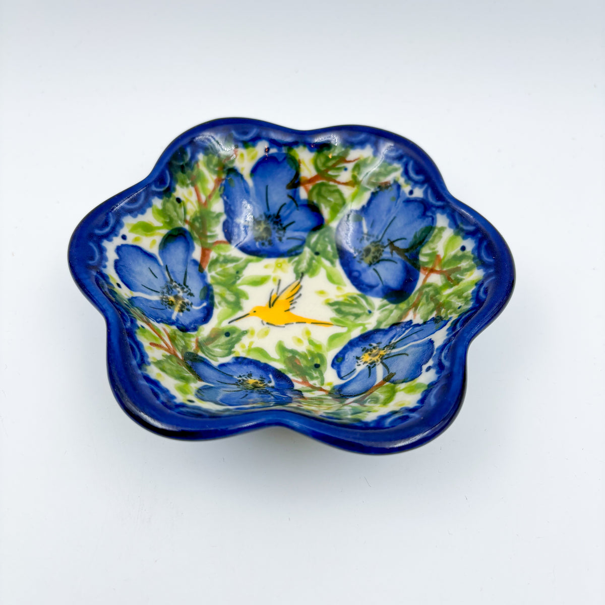 Blue Poppy Songbird flower-shaped bowl on white background, top-down view showing songbird