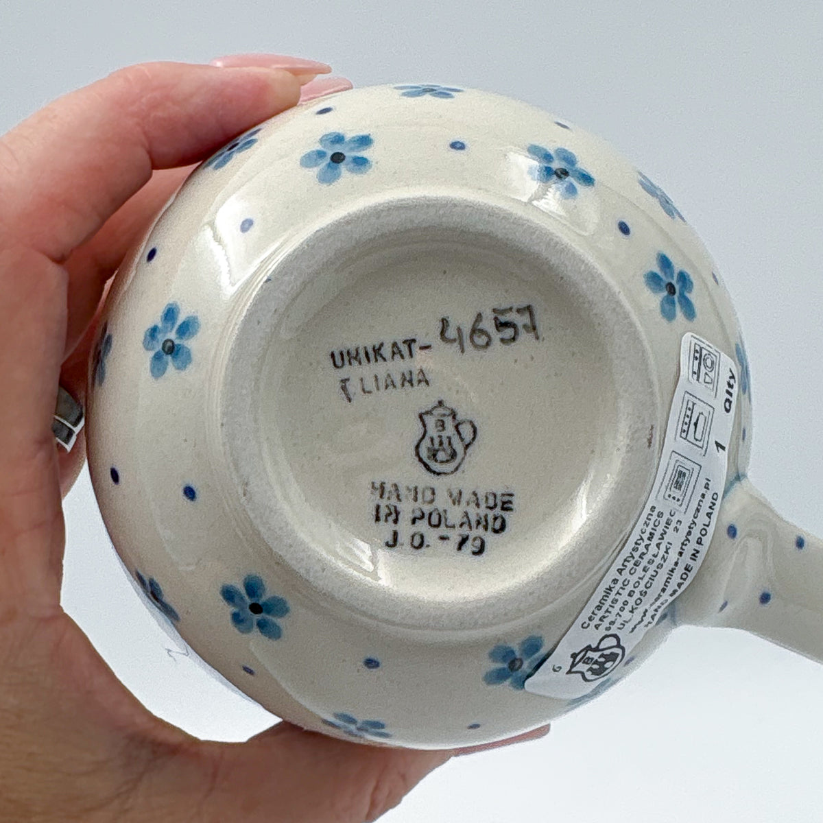 Bottom of Morning Glory bubble mug showing Unikat stamp and artist signature, held in hand