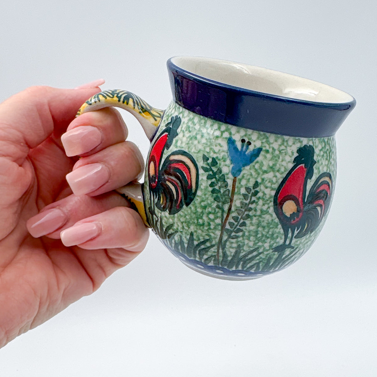Rooster Parade bubble mug held in hand, front view