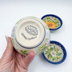 UNIKAT Orange Poppy small stacking bowl set, bottom stamp of large bowl held in hand with two smaller bowls behind