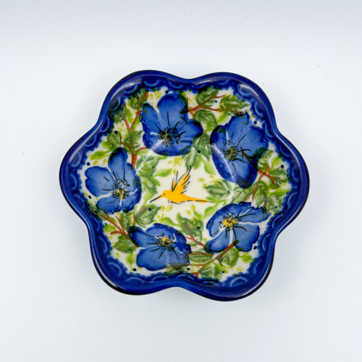 Blue Poppy Songbird flower-shaped bowl on white background, top-down view