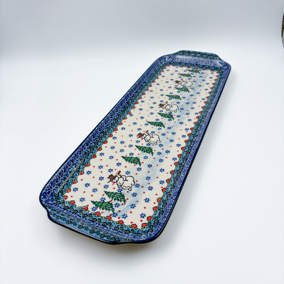 UNIKAT Snowman Stroll rectangular platter, angled top-down view of full platter with snowmen and pine trees