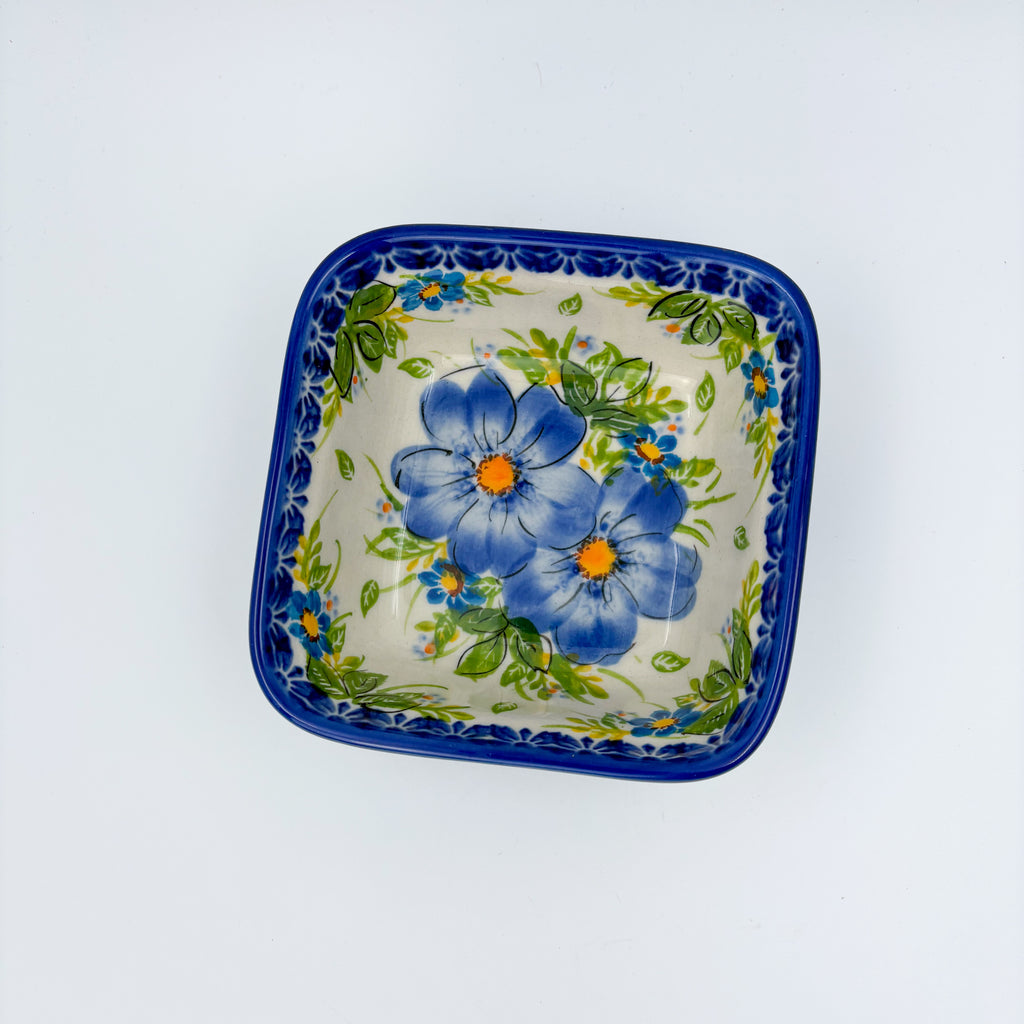 Blue Daisy square bowl on white background, top-down straight-on view