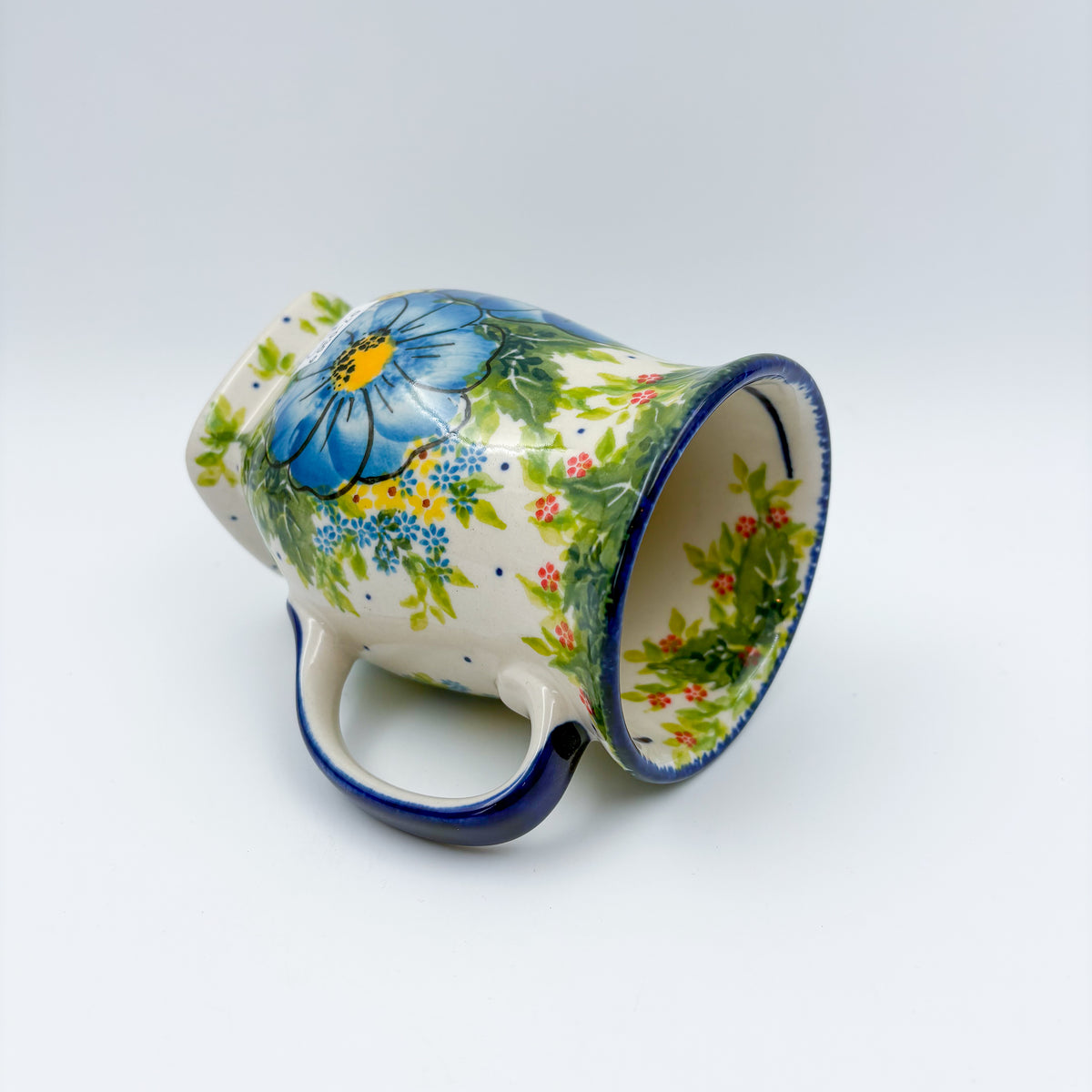 Blue Poppy Dance tulip mug tipped on its side, alternate angle showing interior and pattern