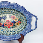 Iris Meadow oval platter with handles, close-up view of cutout handle and floral bouquet with scalloped border