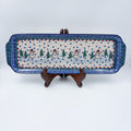 UNIKAT Snowman Stroll rectangular platter with handles, front view on stand showing snowmen and pine trees