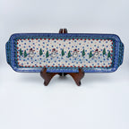 UNIKAT Snowman Stroll rectangular platter with handles, front view on stand showing snowmen and pine trees
