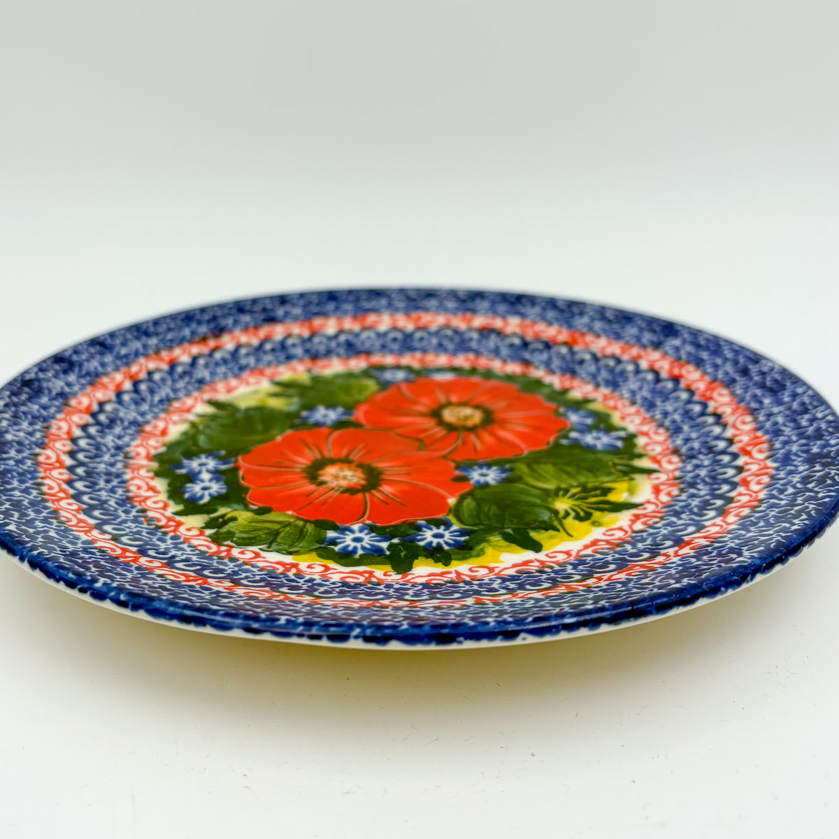 UNIKAT Red Finesy plate, front view showing red poppy cluster and red-and-blue scroll border