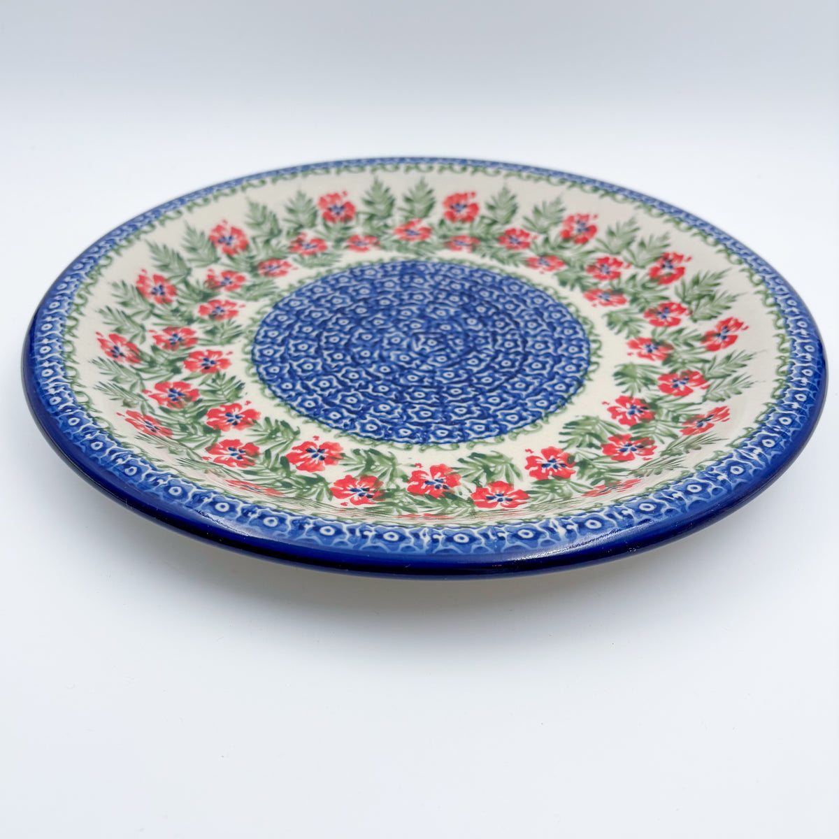 Midsummer Bloom plate, angled front view showing red flower ring around blue mosaic center