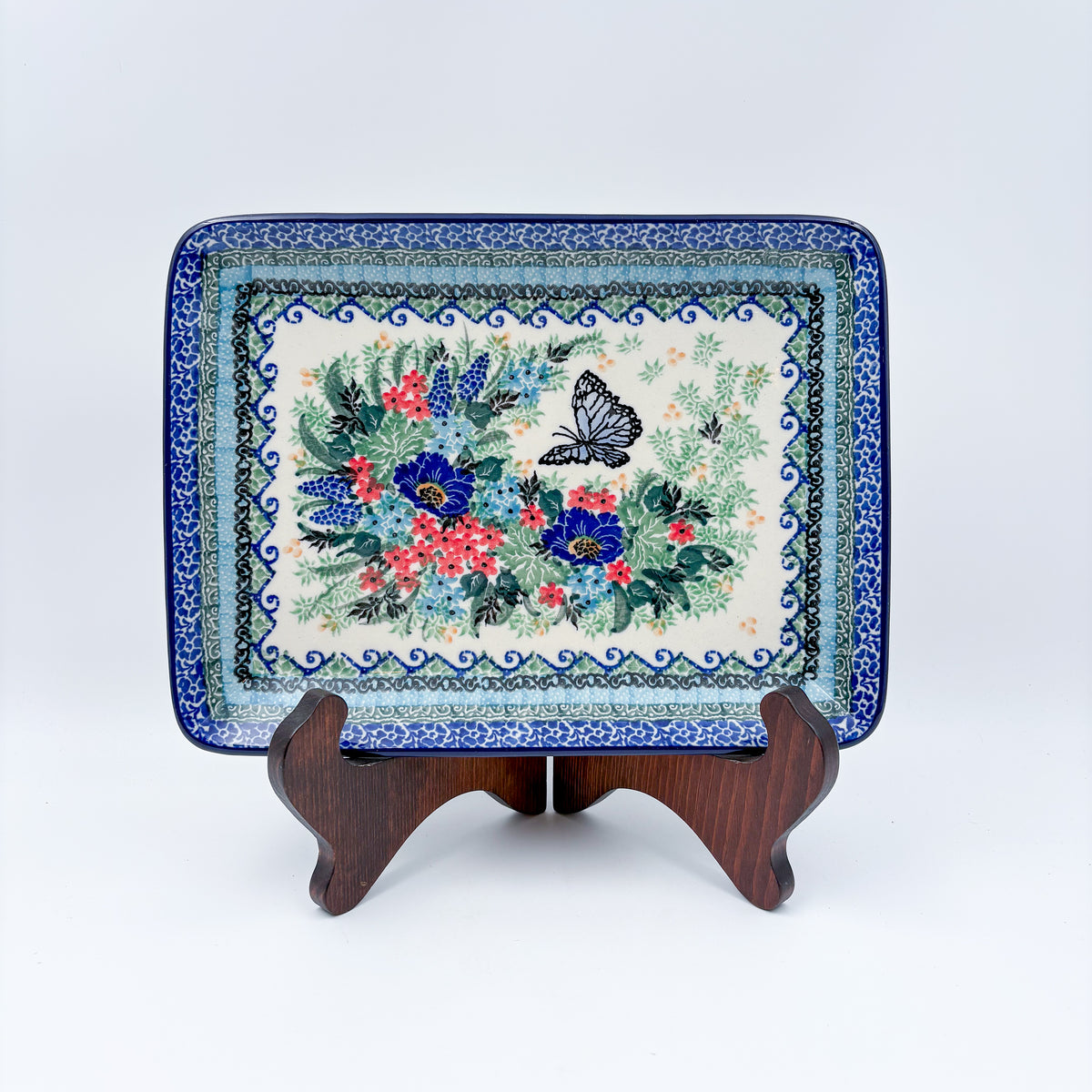 Mariposa rectangular platter, front view on stand showing black butterfly and floral bouquet