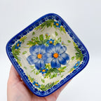 Blue Daisy square bowl held in hand, top-down view