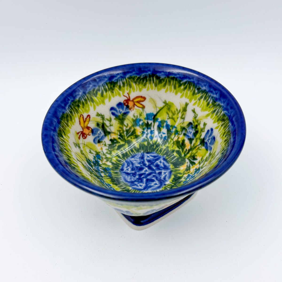 Bluebell Meadow small pedestal bowl, top-down view showing bluebell flowers and butterflies around blue center