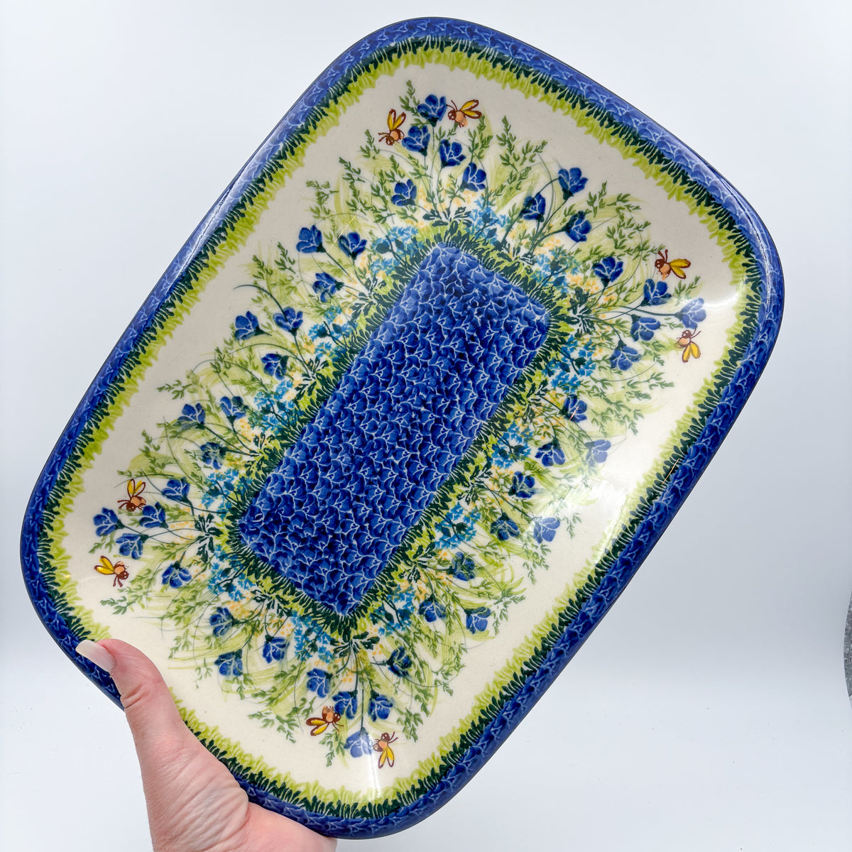 UNIKAT Bluebell Meadow large Daria platter held in hand, top-down view of full bluebell platter