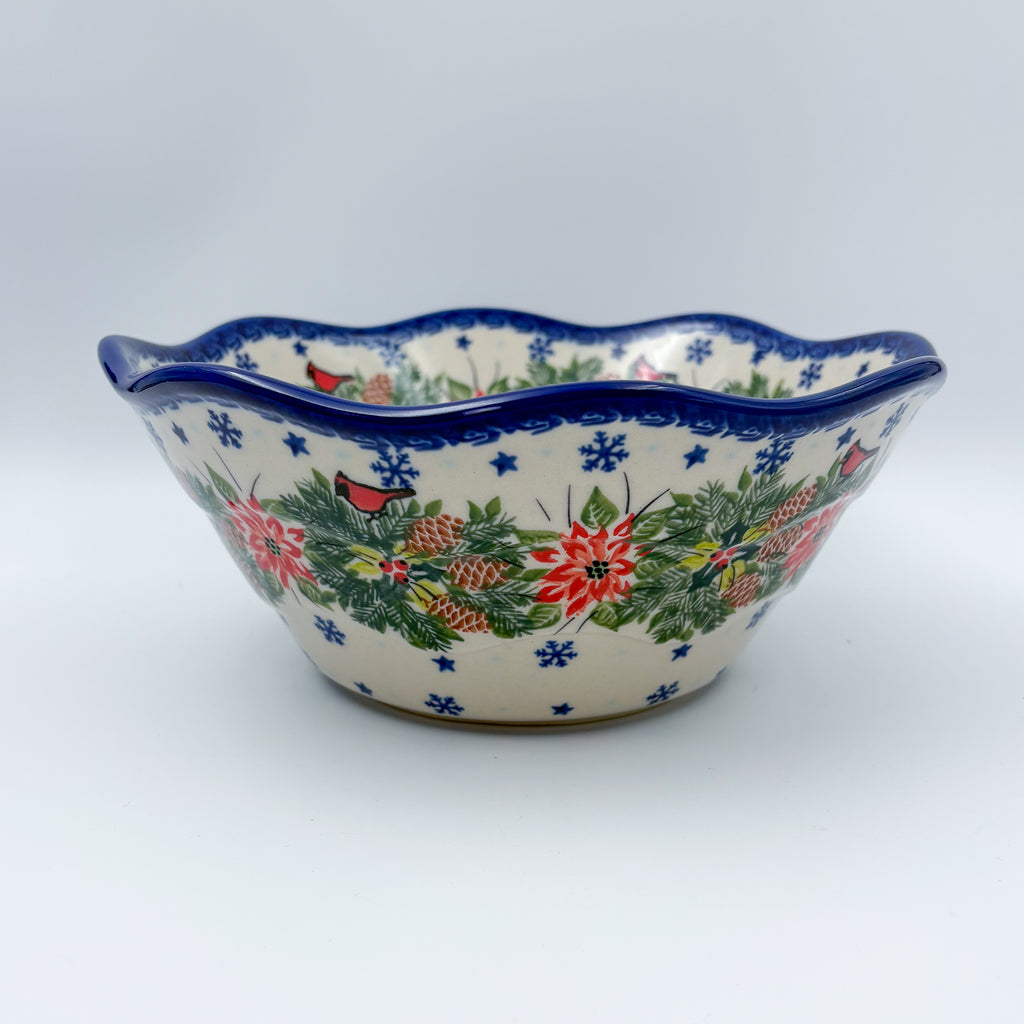 Christmas Cardinals wavy bowl, angled front view of poinsettia and pinecone wreath on wavy rim