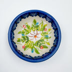 UNIKAT Orange Poppy small stacking bowl set, top-down view of small bowl showing green leaf and floral accent pattern