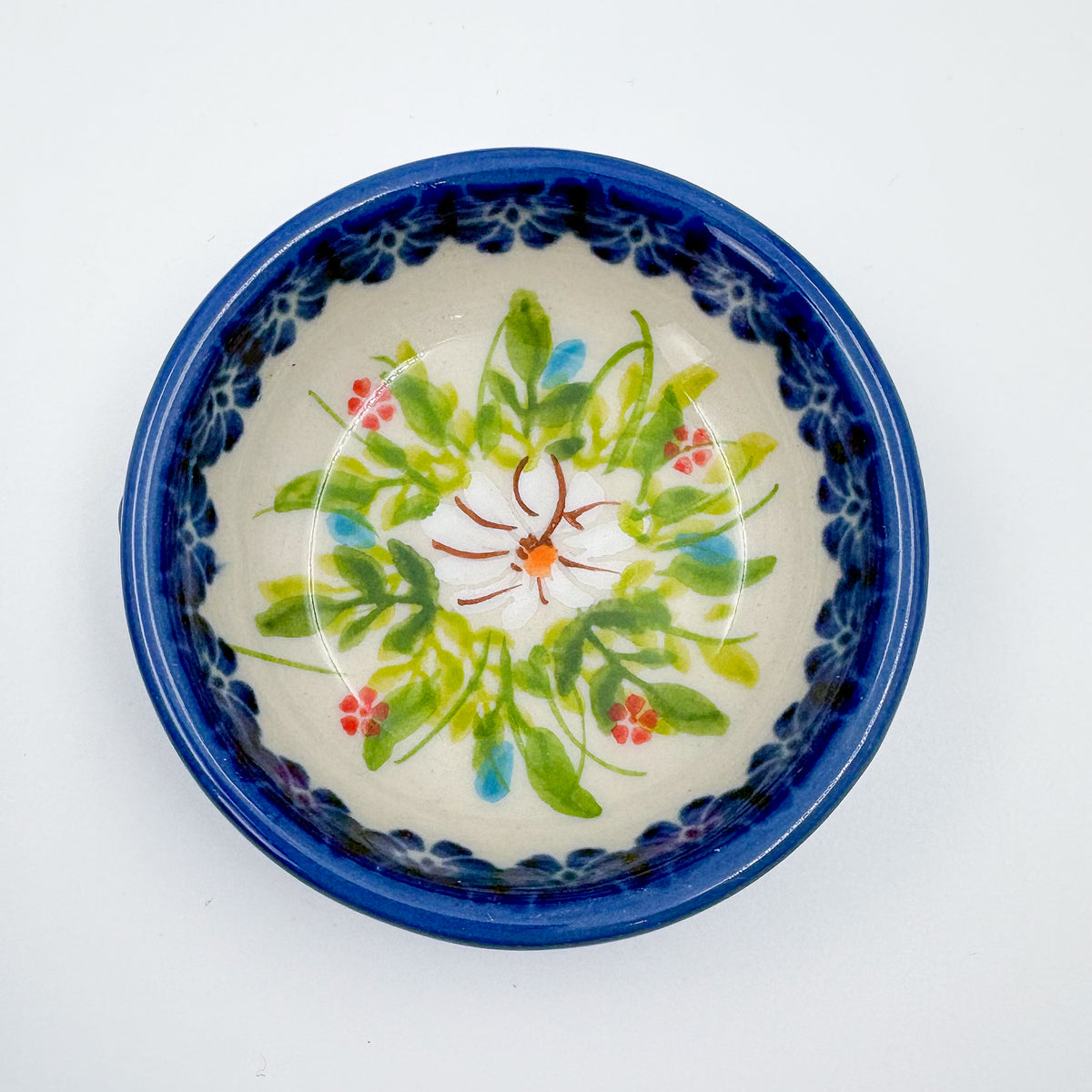 UNIKAT Orange Poppy small stacking bowl set, top-down view of small bowl showing green leaf and floral accent pattern