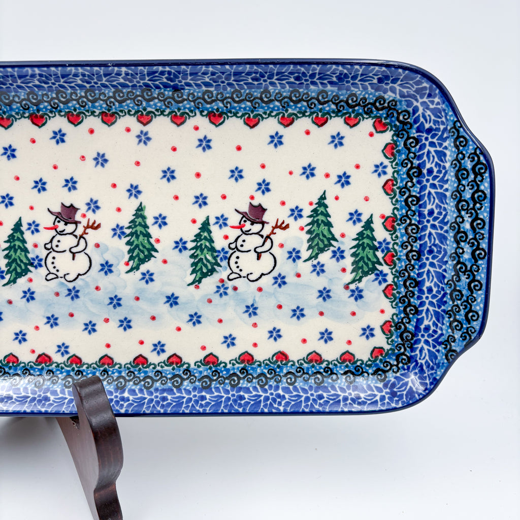 UNIKAT Snowman Stroll rectangular platter, close-up top-down view of snowmen with top hats and pine trees, snowflake field and heart border