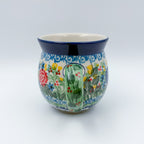Butterfly Garden bubble mug on white background, angled view with green handle