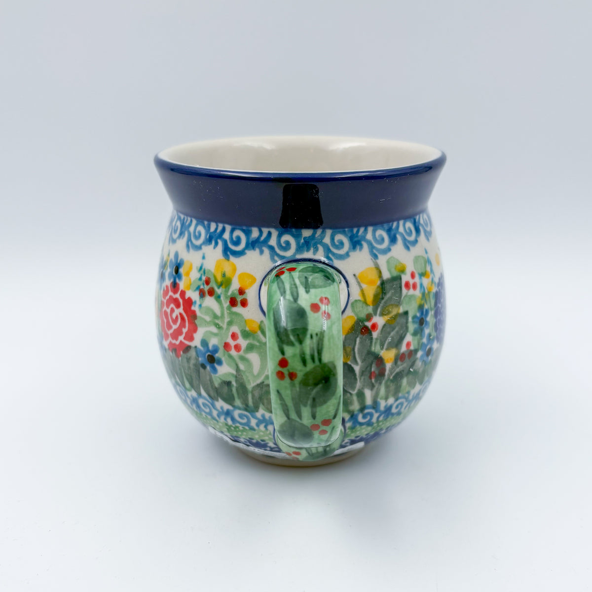 Butterfly Garden bubble mug on white background, angled view with green handle