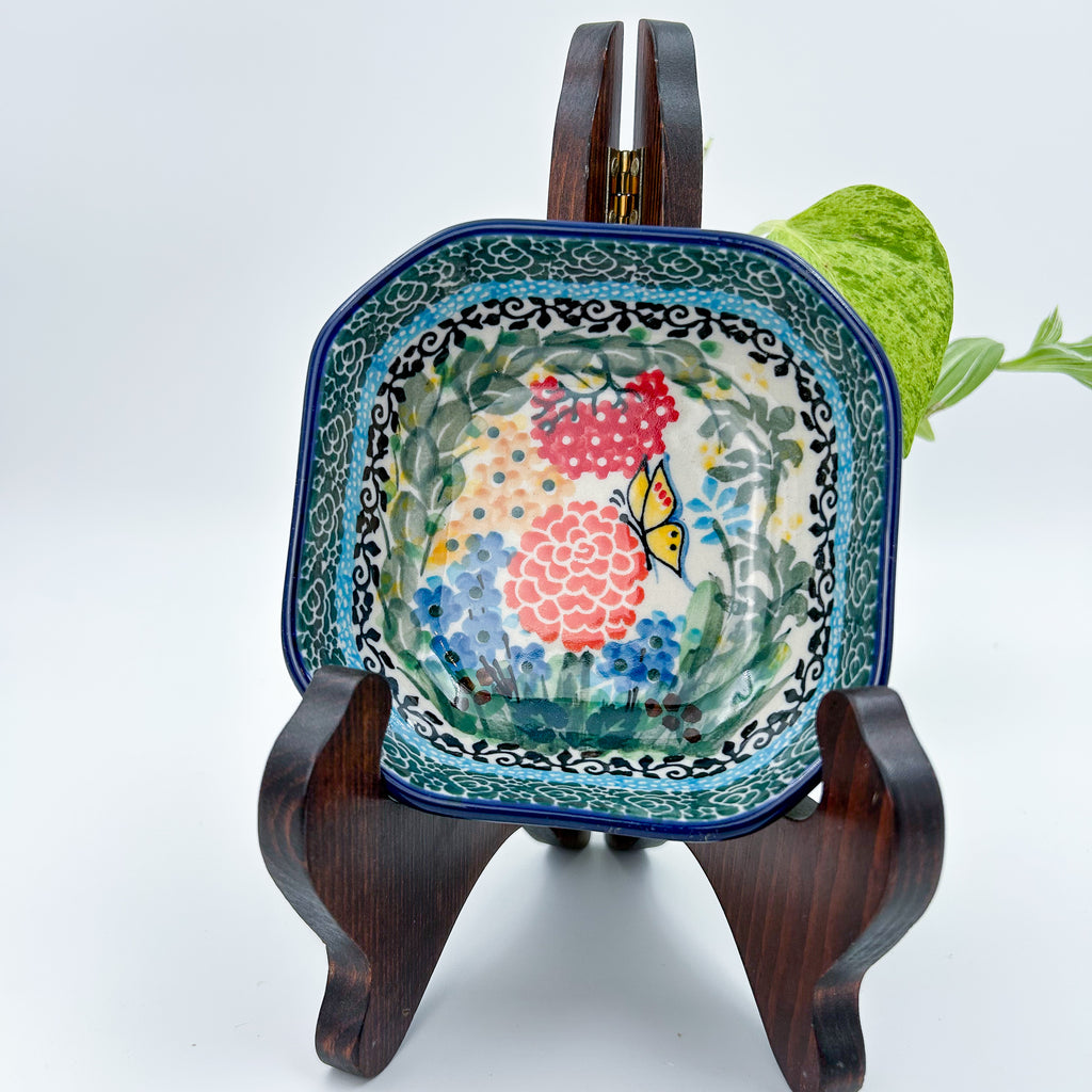 Butterfly Garden square bowl on display stand, top-down view