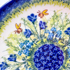 UNIKAT Bluebell Meadow plate, close-up top-down view of bluebell flowers, bees, and navy mosaic center