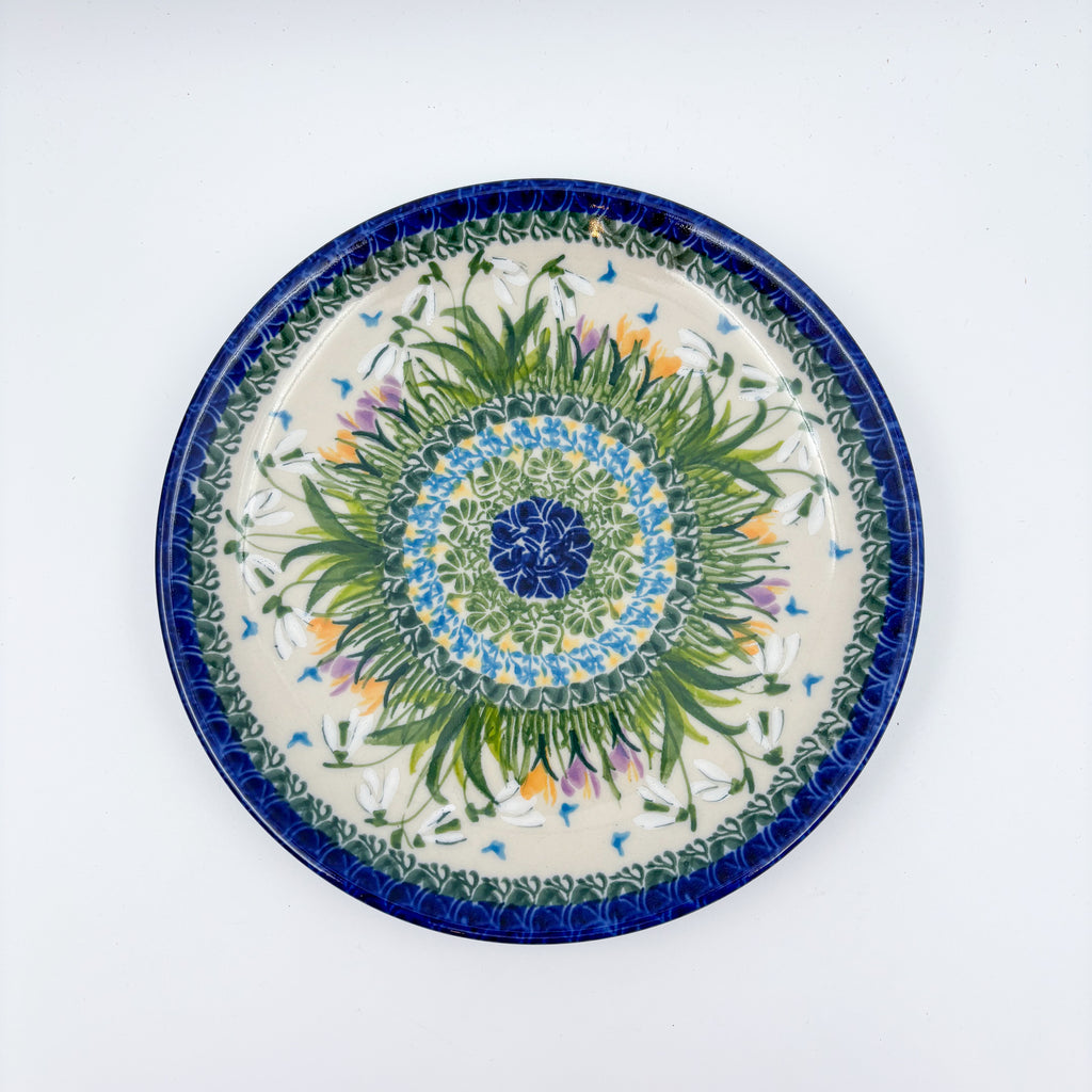 UNIKAT Snowdrop Garden plate, top-down view of green grass burst center with white snowdrops and orange crocuses