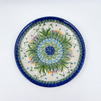 UNIKAT Snowdrop Garden plate, top-down view of green grass burst center with white snowdrops and orange crocuses